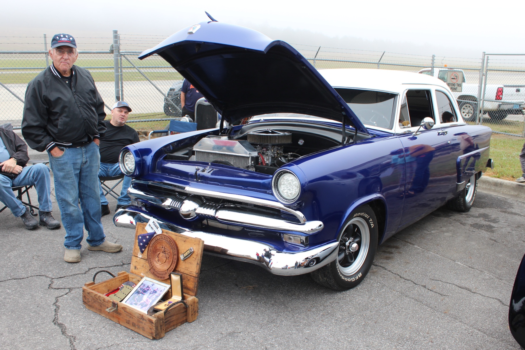 Blue-and-white 1953 Ford custom with USMC memorial display at its bumper