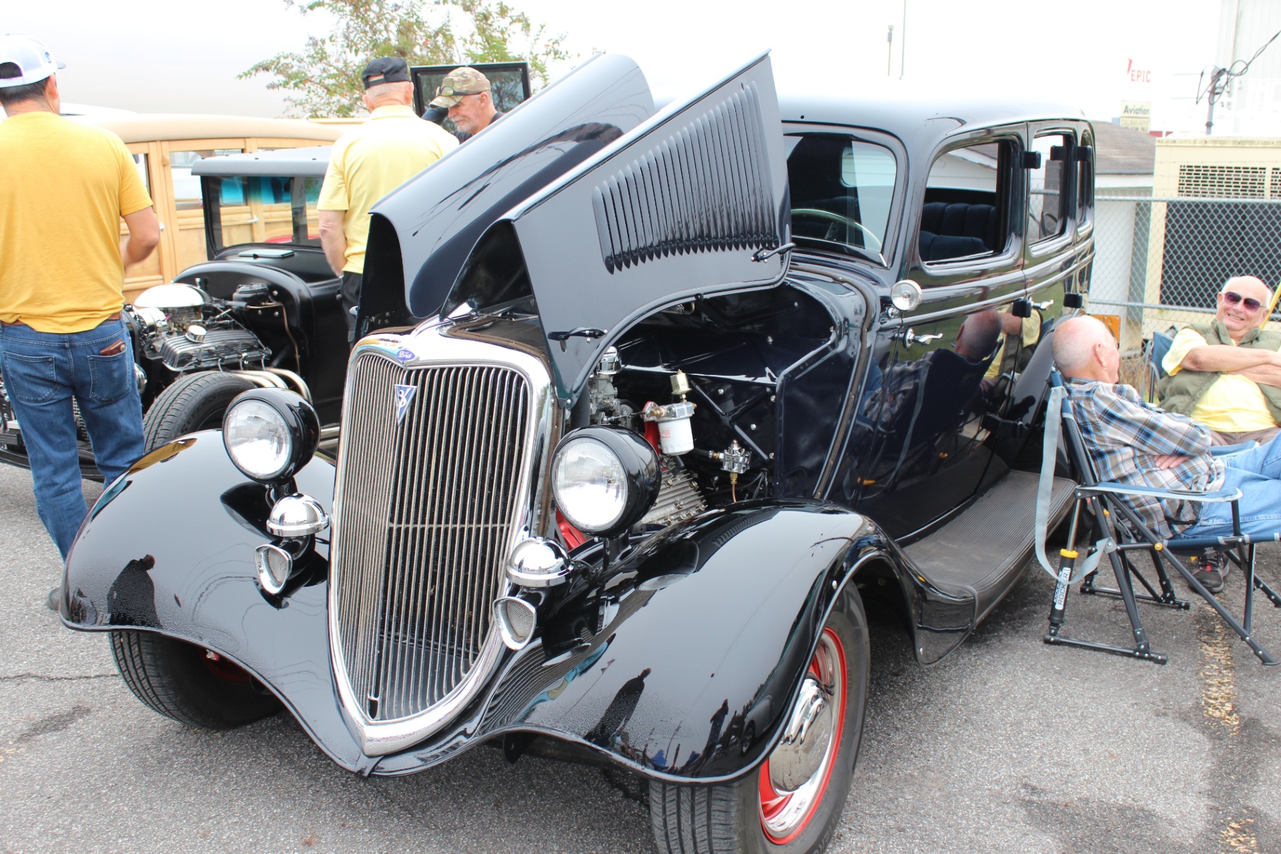 Glossy black 1934 Ford sedan with hood open at the veterans car show