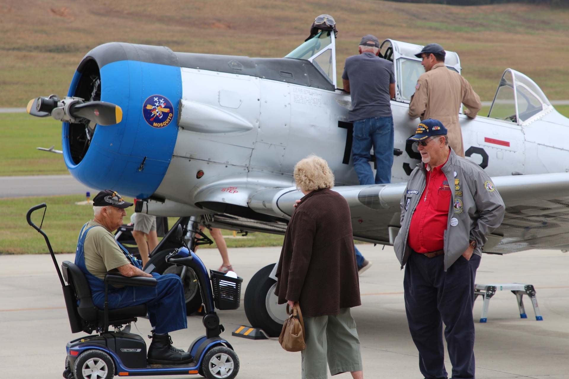 Veteran visiting a T-6 'Mosquito' trainer on the flight line
