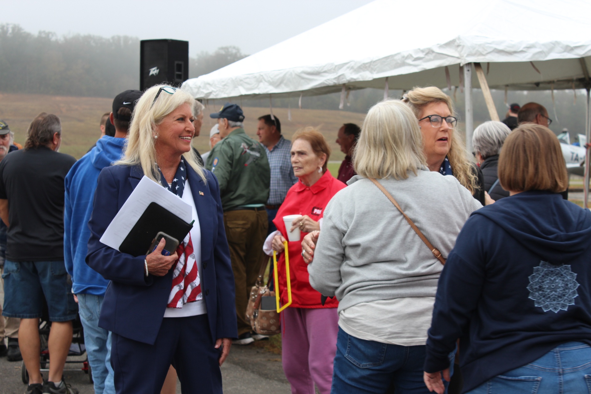 Congressional guest speaker greets attendees in the misty morning