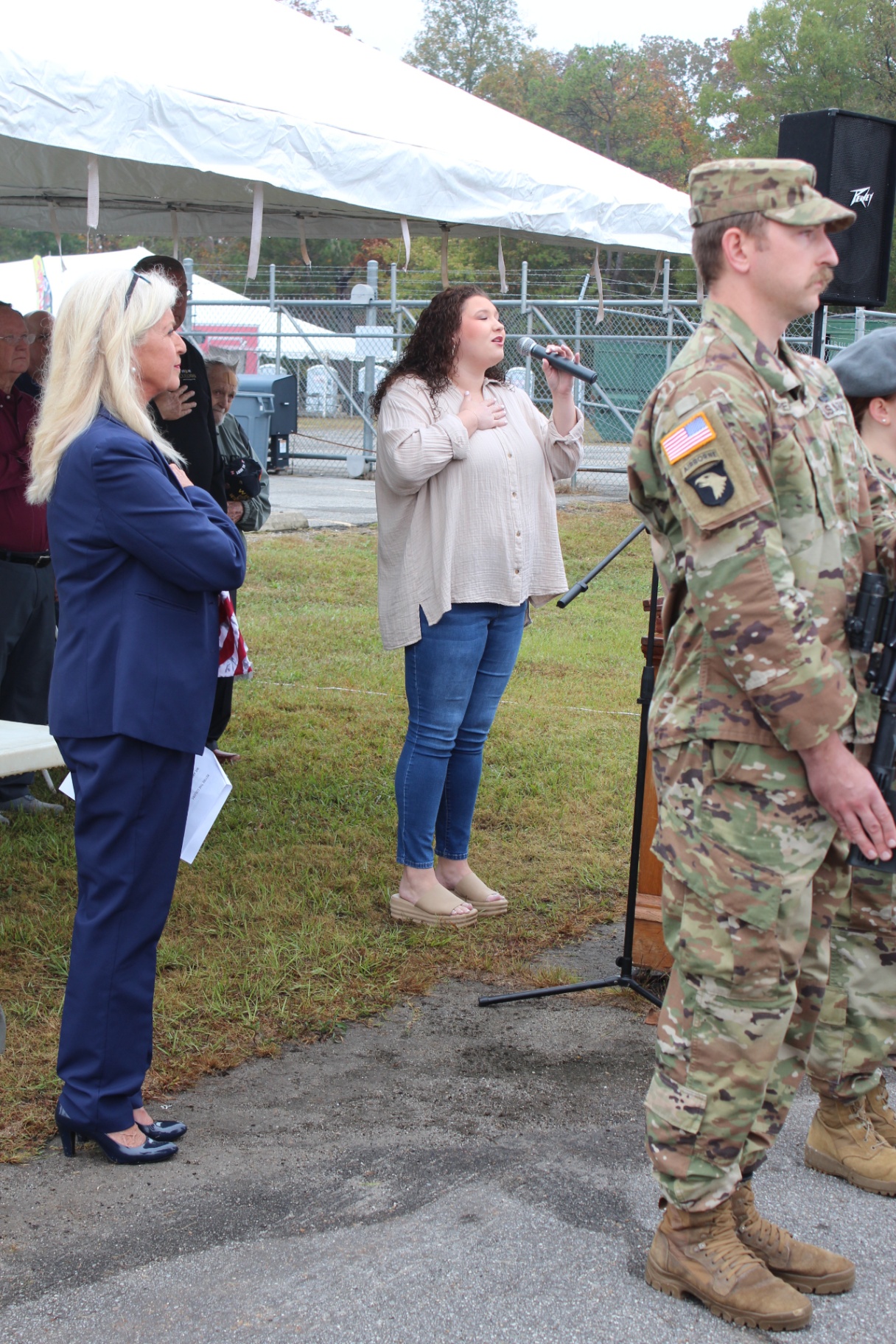 Vocalist performs the National Anthem beside a 101st Airborne soldier