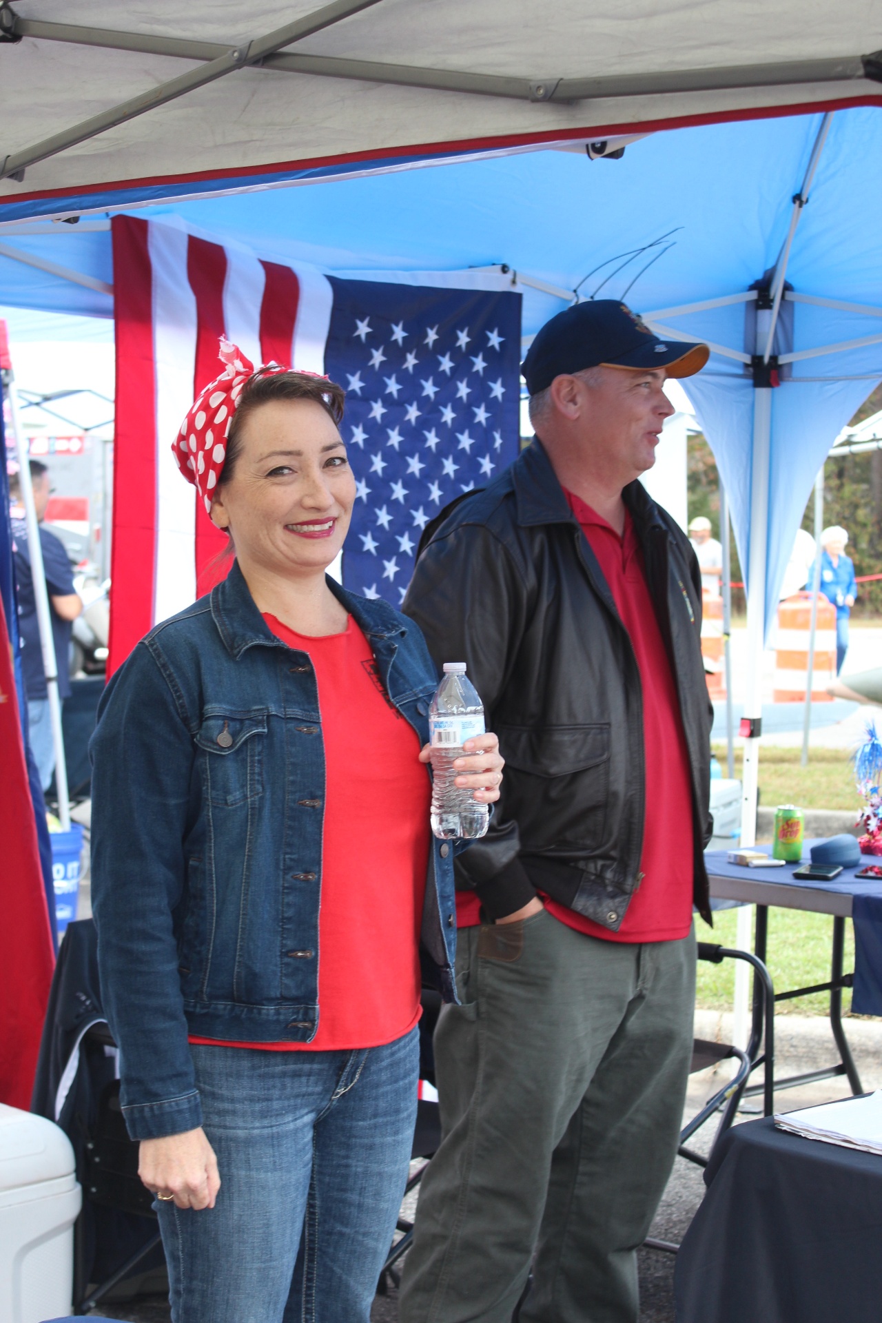 Rosie the Riveter reenactor beside a WWII flight-jacket volunteer