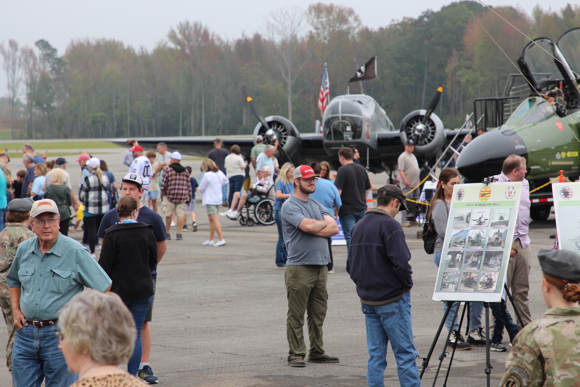 Crowds gather around WWII bomber and Vietnam-era Cobra