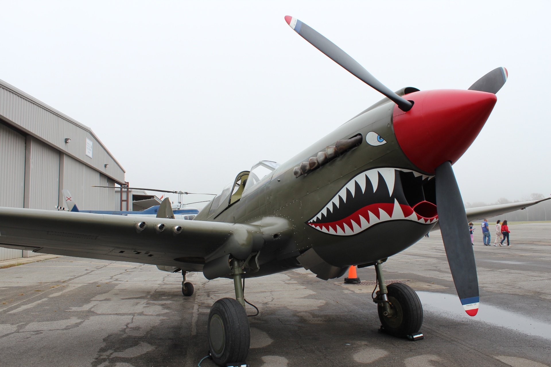 Curtiss P-40 Warhawk with shark-mouth nose art on the misty ramp