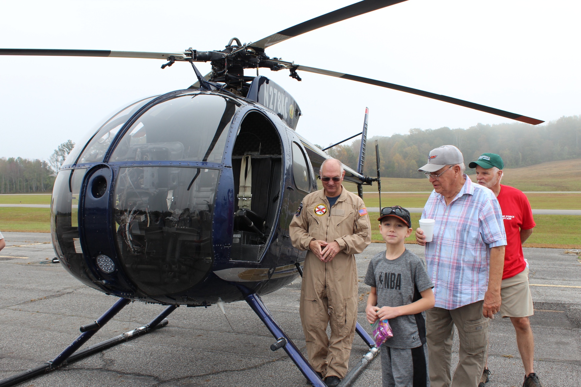 Hughes OH-6 Cayuse helicopter with pilot and visitors