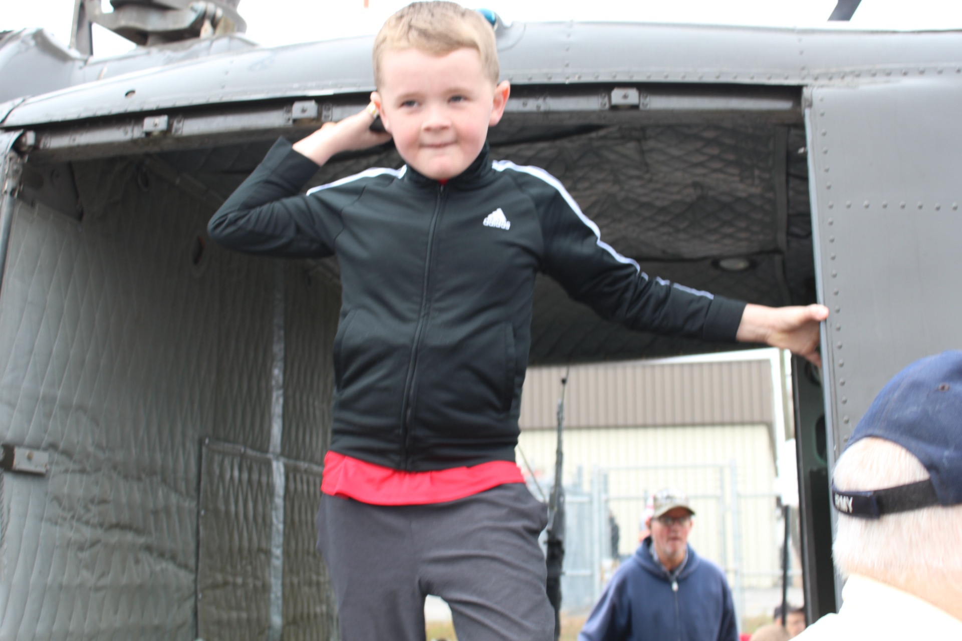 Excited child hopping down from a UH-1 Huey doorway
