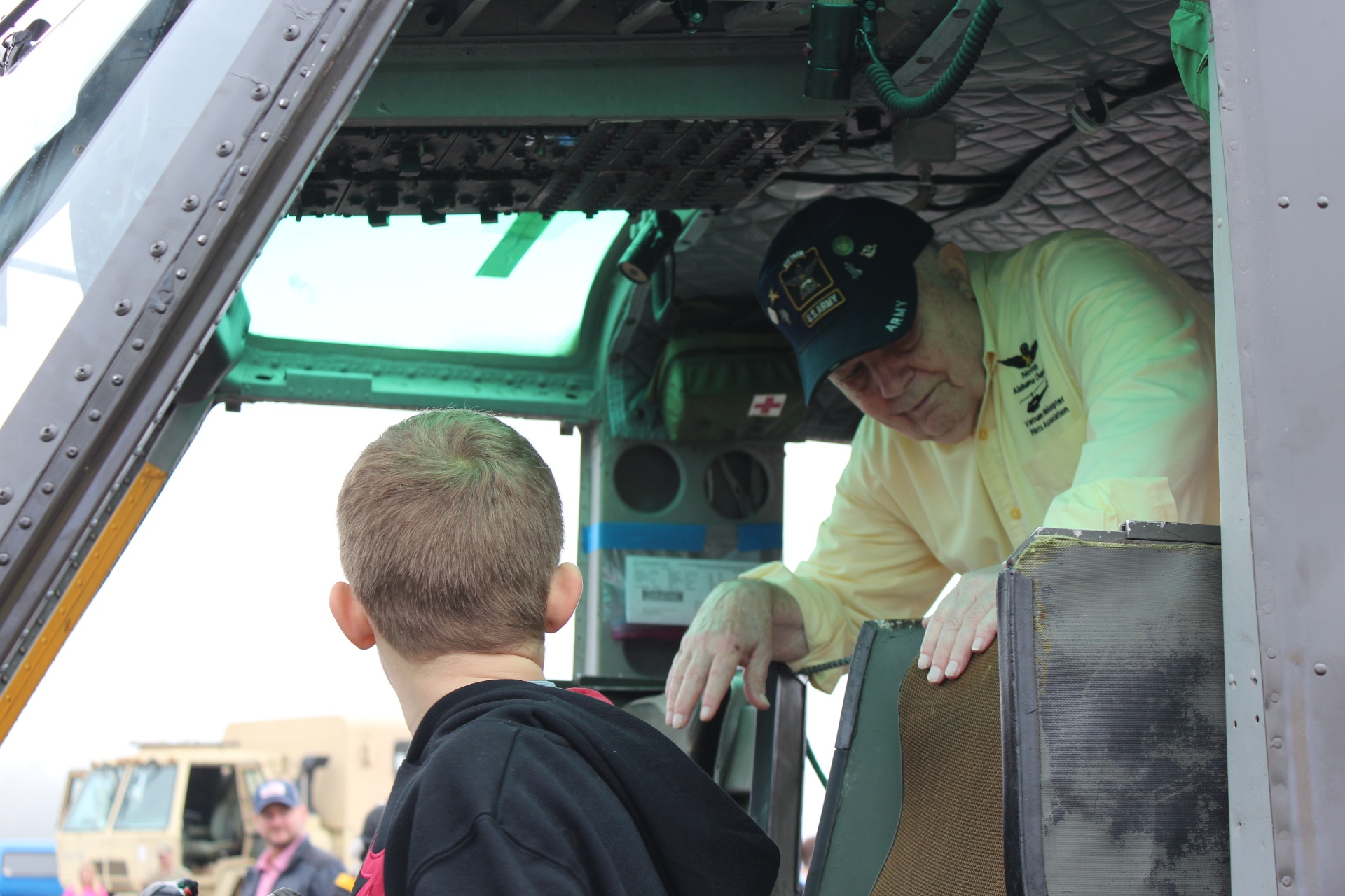 Vietnam helicopter pilot welcomes a young visitor into a Huey