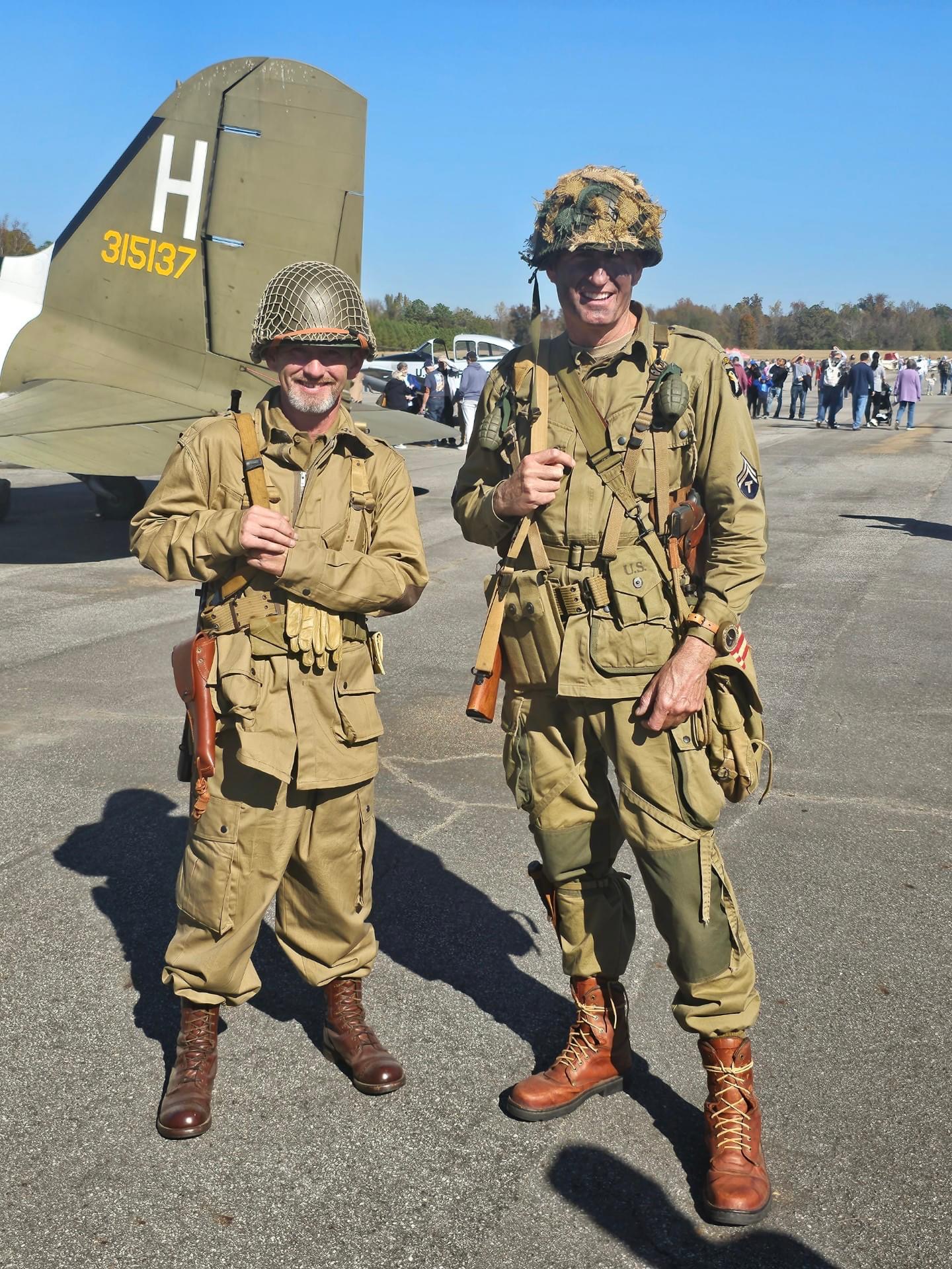 WWII 101st Airborne paratrooper reenactors beside a C-47
