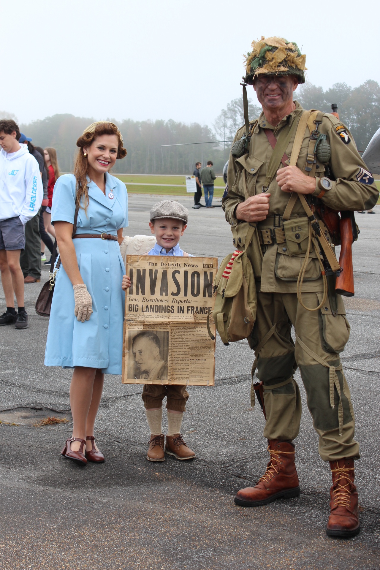 Rosie the Riveter reenactor, young newsboy, and 101st Airborne paratrooper