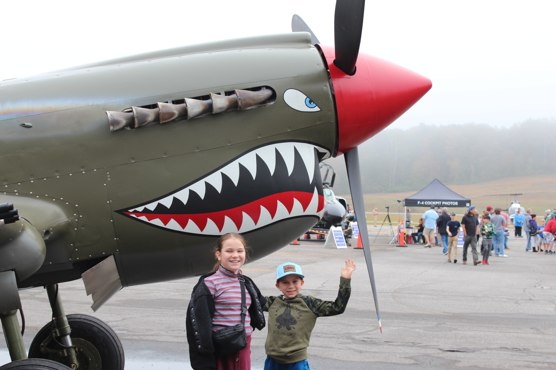 Kids pose with the shark-mouth P-40 Warhawk on the flight line