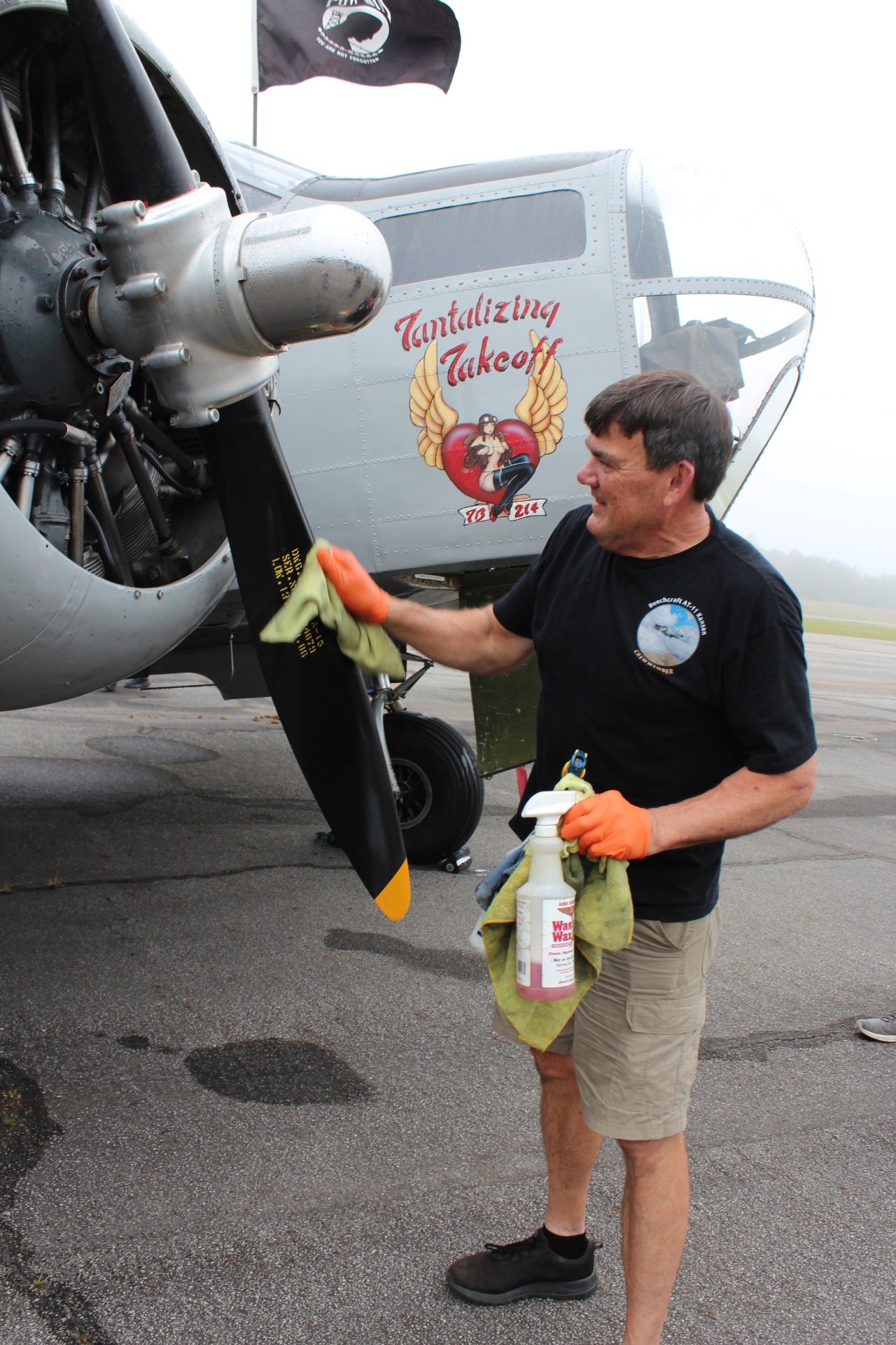 Crew member polishes the 'Tantalizing Takeoff' Beechcraft nose art