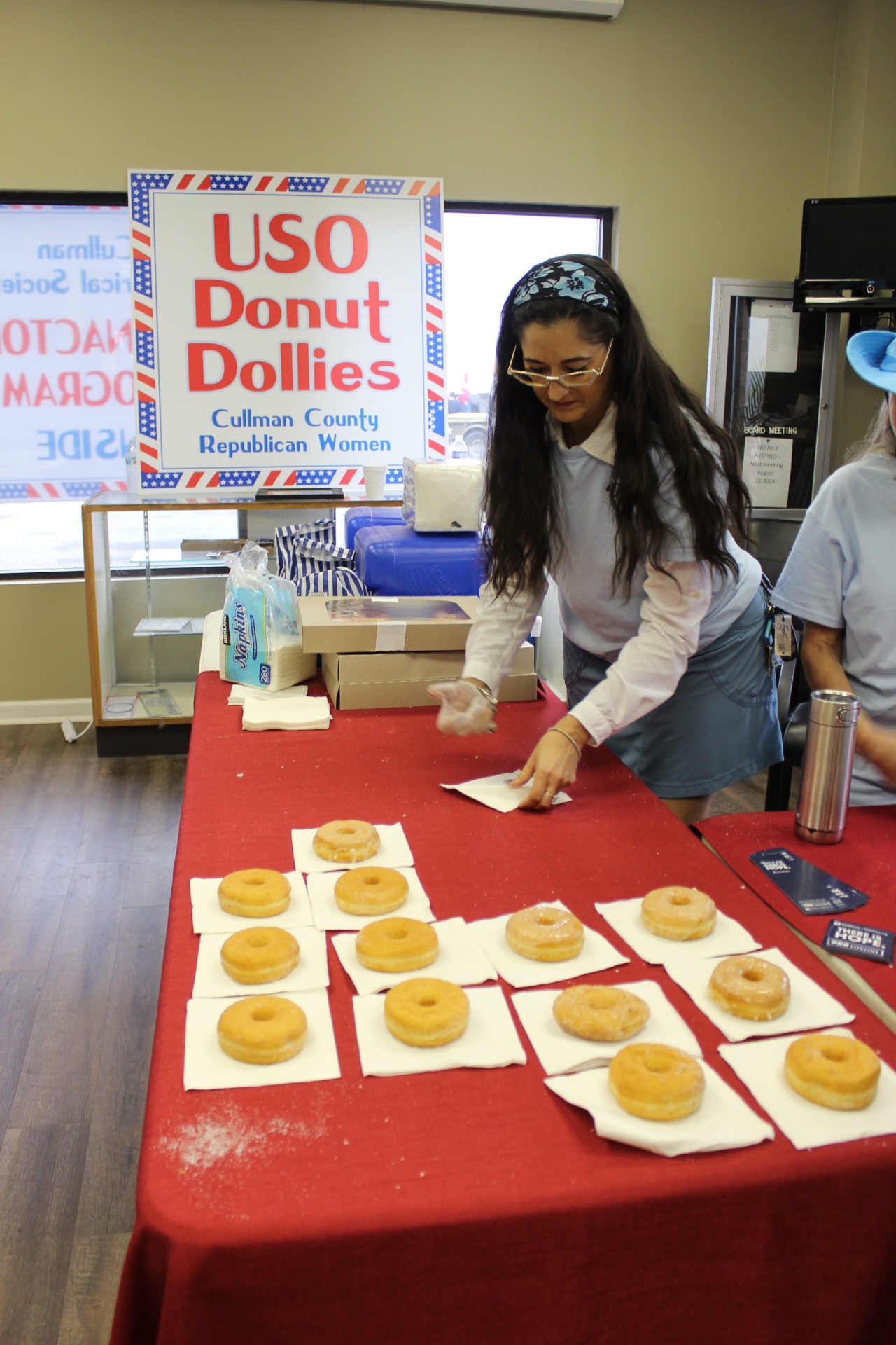 USO Donut Dolly setting up glazed doughnuts for veterans